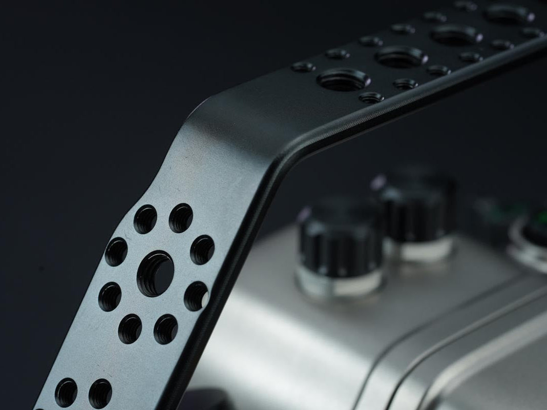 Metallic armrest with perforated design on a dark background