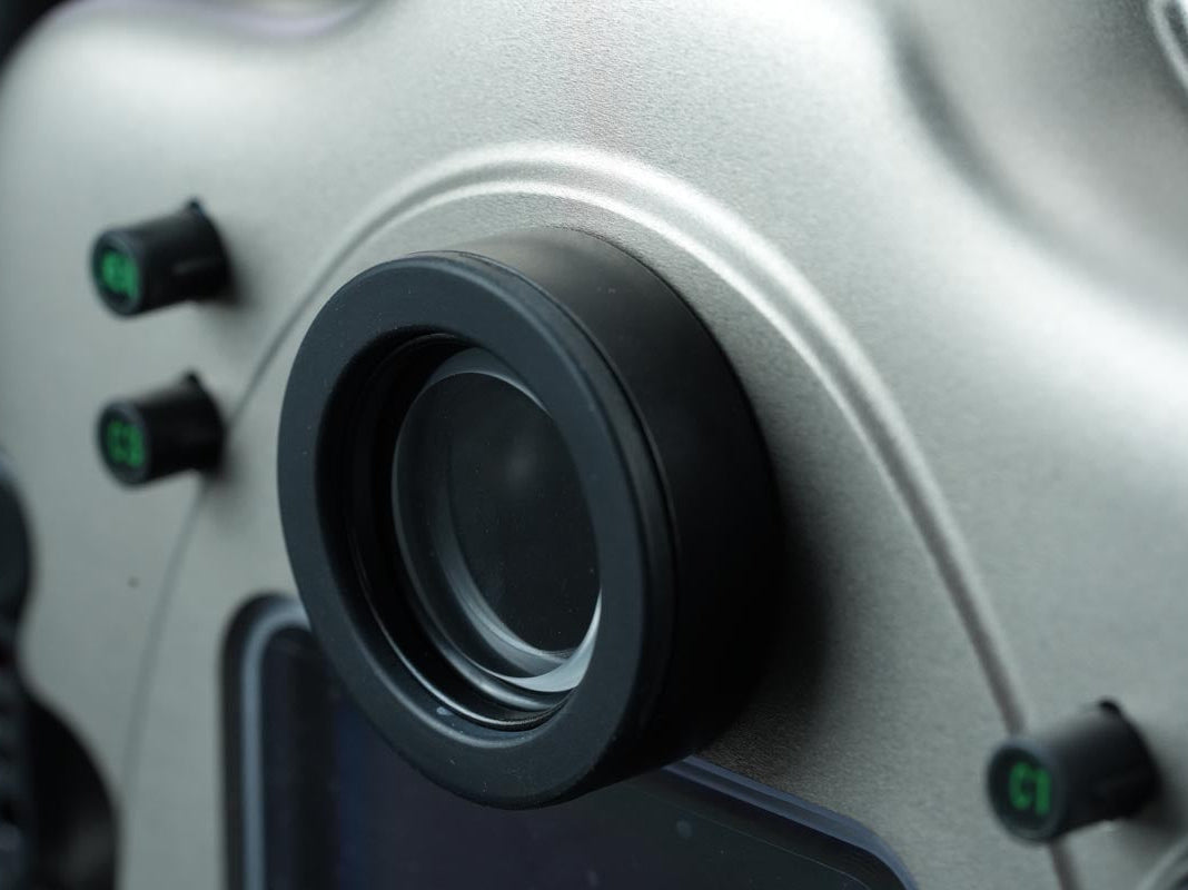 Close-up of a camera lens and control knobs on a piece of electronic equipment.