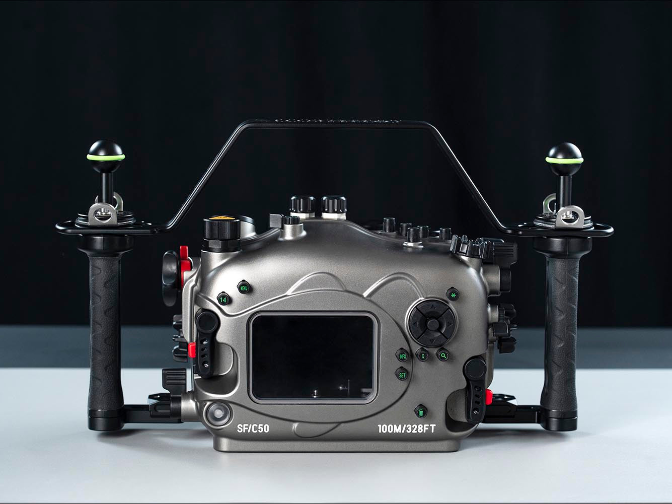 A professional underwater camera housing rig, specifically a Divercam SPC-60 100M/92FT rig, featuring a matte gray aluminum body, black handles, and a clear top handle frame, set against a dark studio background.
